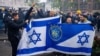 Supporters of Maccabi Tel Aviv hold flags at Dam square ahead of the Europa League football match between Ajax and Maccabi Tel Aviv, in Amsterdam on November 7, 2024. (Photo by Jeroen Jumelet / ANP / AFP) / NETHERLANDS OUT